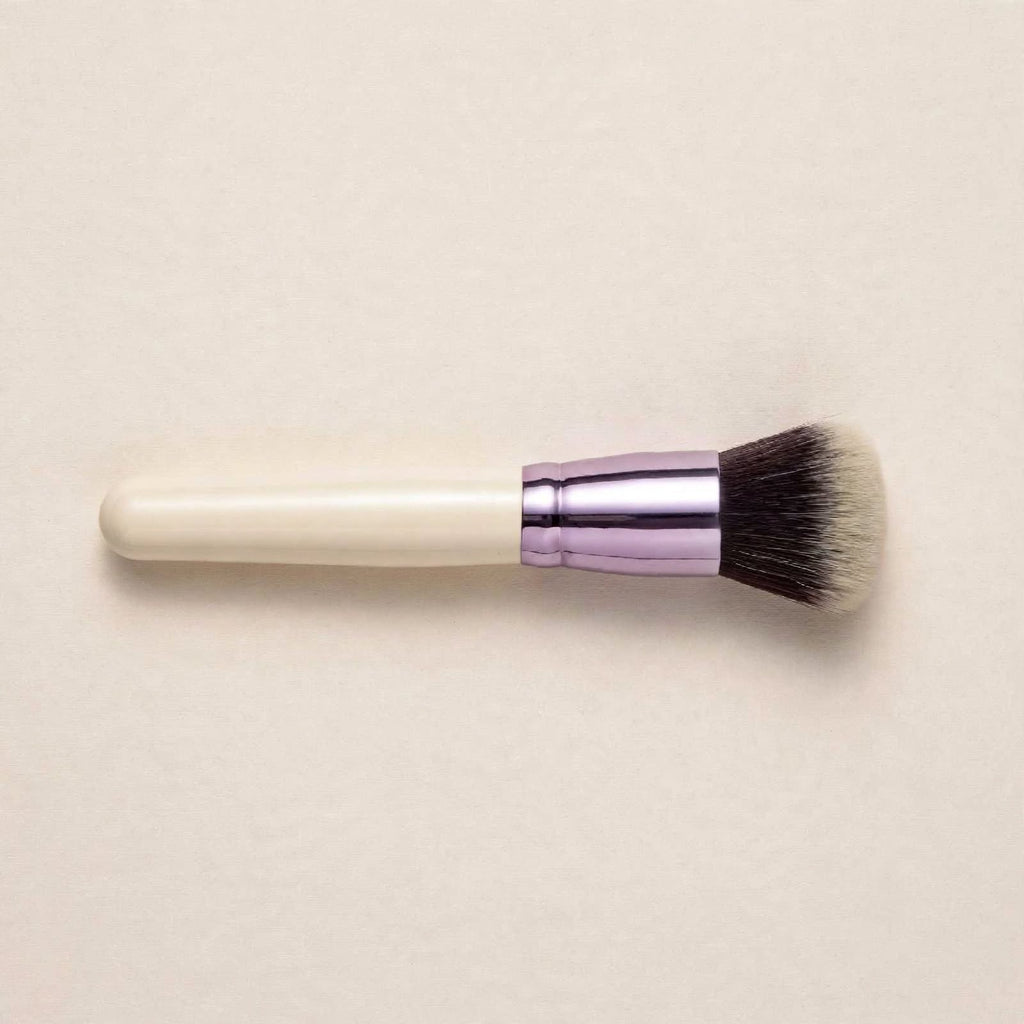 Cream handle powder brush lying flat
