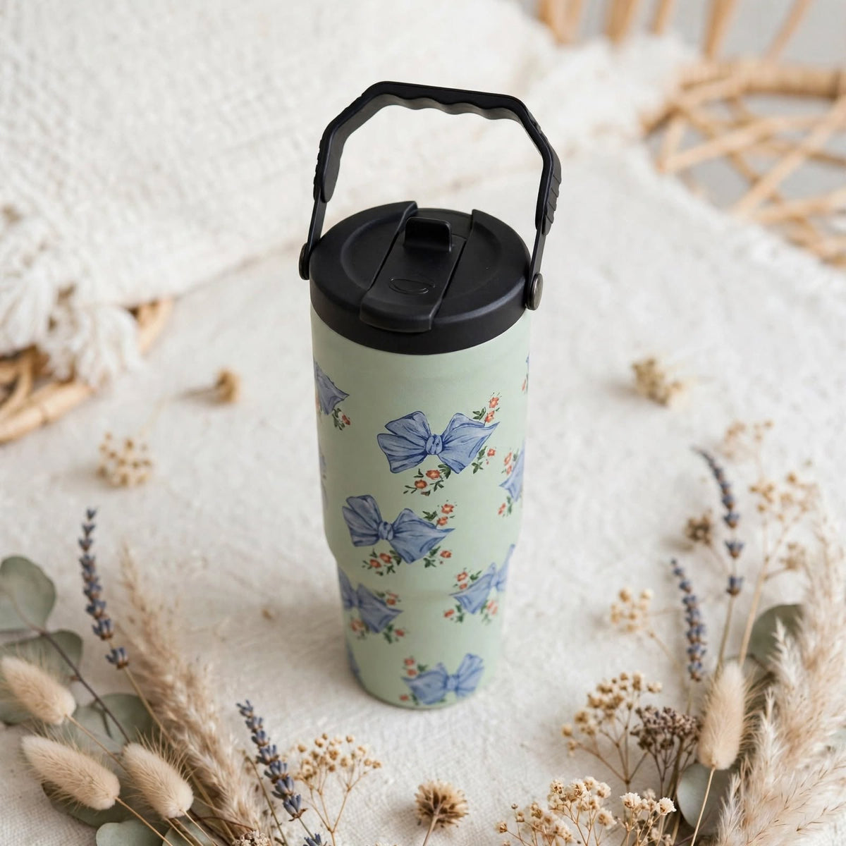 Sage green travel tumbler with blue bows, styled