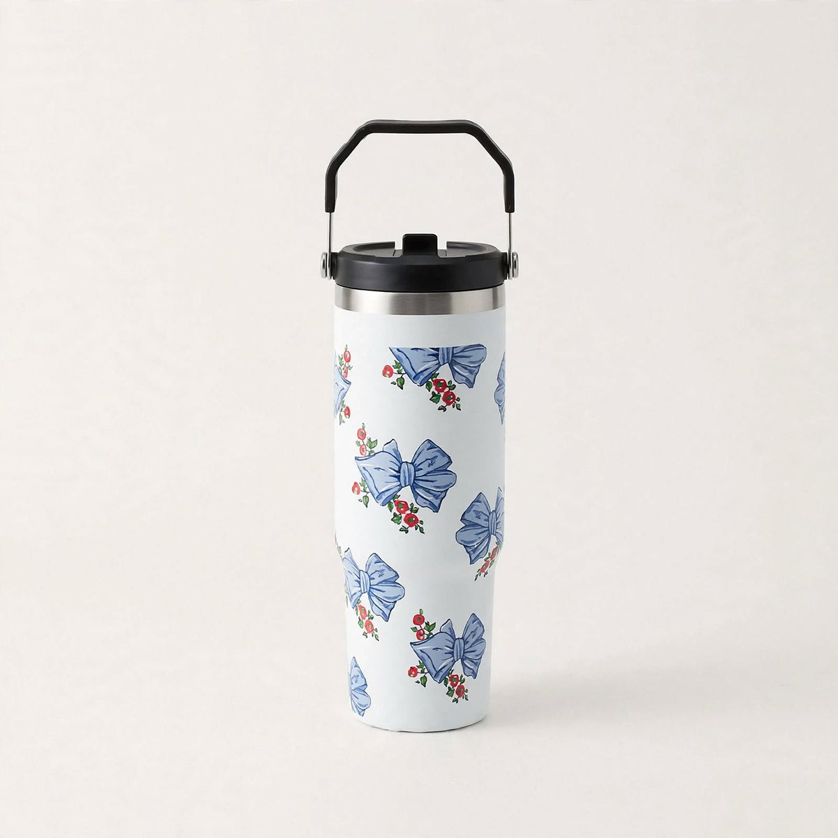 White travel tumbler with blue bows, front