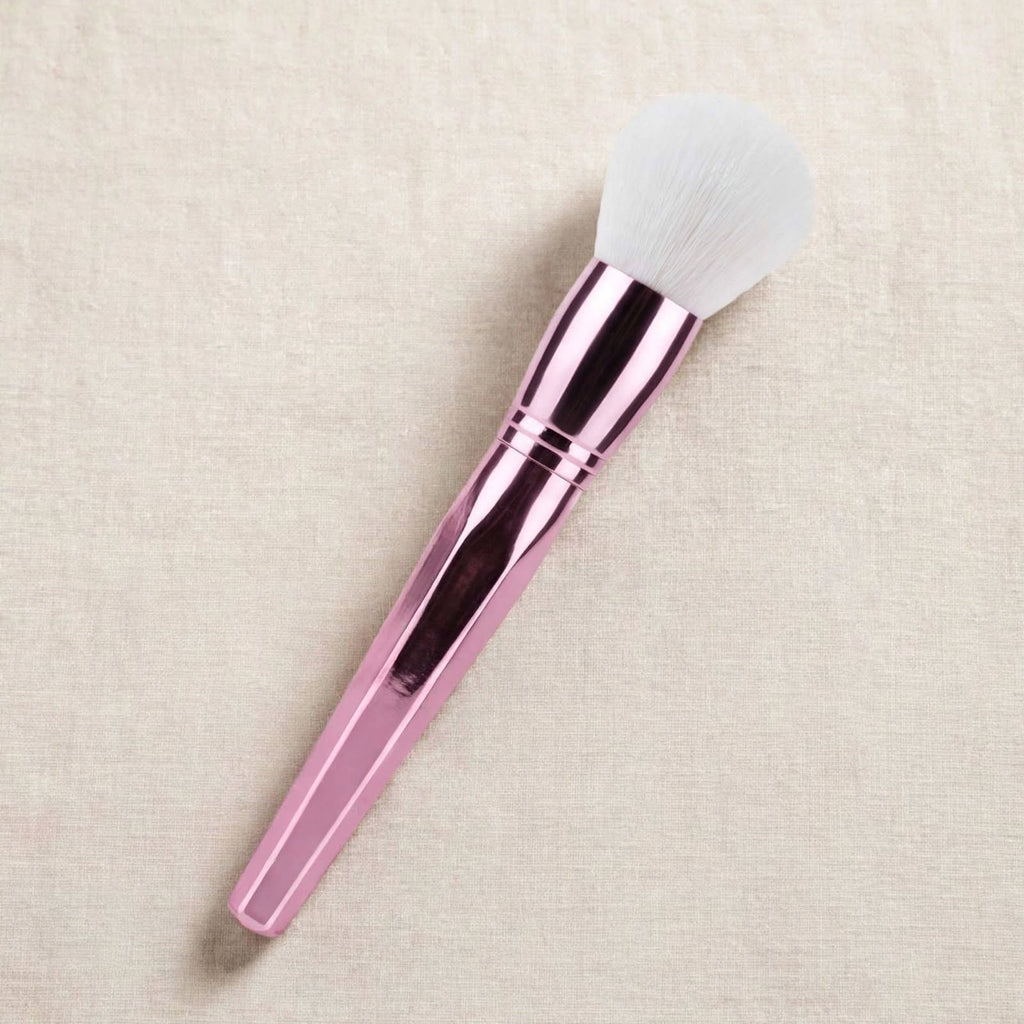 Rose pink fluffy powder brush lying flat