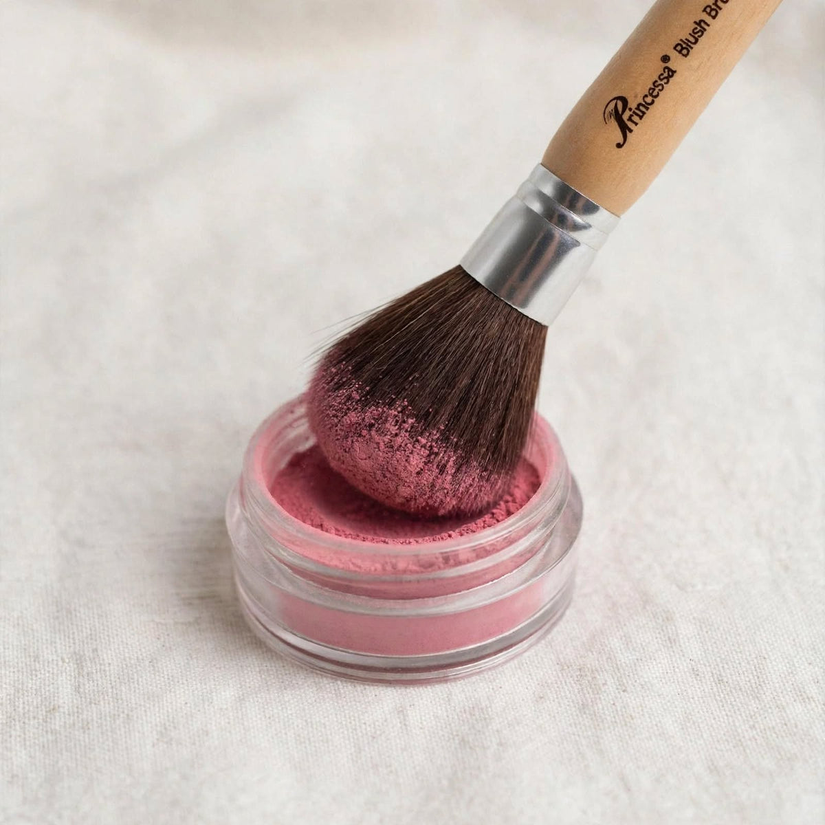Precious powder brush dipped in blush